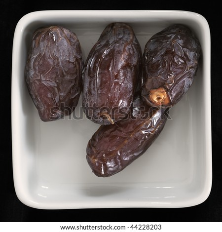 Close-up of dried dates on black background (large format photography)