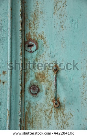 old rusty shabby metal green door with metal handle and door latch