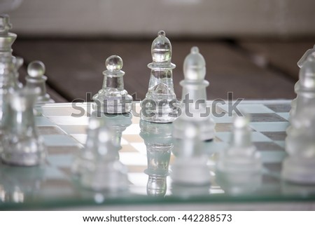 Transparent chess made fo glass on wood background , Focus sharp specific point