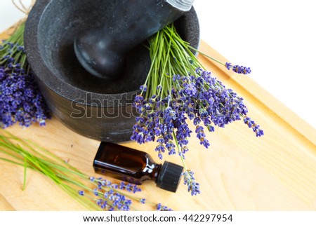 Healing herbs, black mortar with lavender flowers, bottle with oil, herbal medicine
