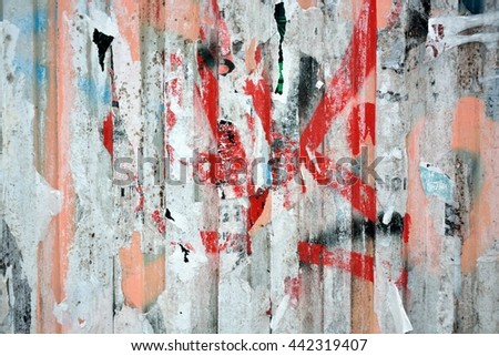 Colorful torn posters on grunge old walls as creative and abstract background