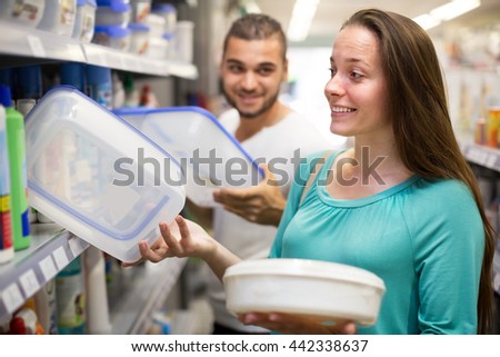 Adult woman in good spirits selecting pails at the store 
