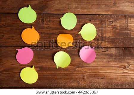 Multicolored paper stickers on wooden table.