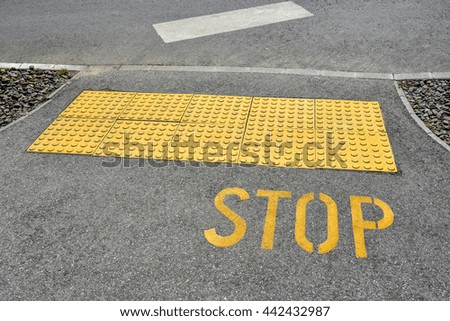 Stop sign on the asphalt at the road crossing