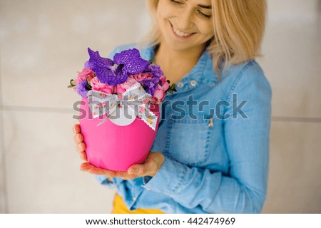 girl holding beautiful pink bouquet of mixed flowers in vase