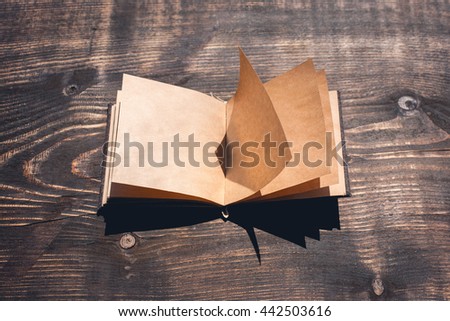 open blank vintage notebook over wooden desk. with empty space for your art or text presentation