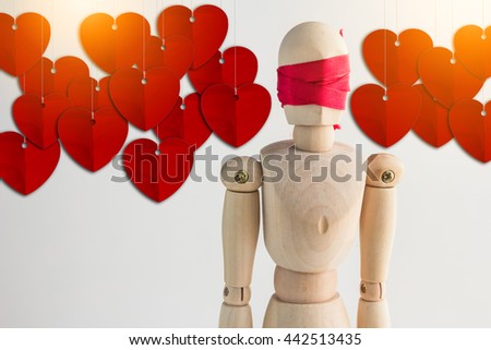 wood man figure blind with red ribbon and red heart hanging for background love concept