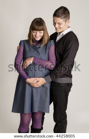 Beautiful pregnant woman with her husband studio portrait