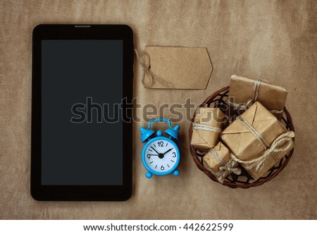 tablet, basket of gifts box, alarm clock and paper tag, buying concept 