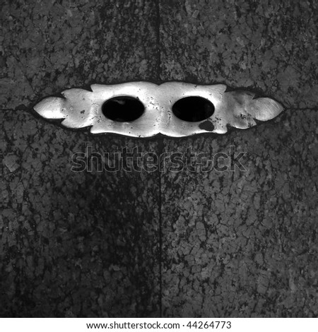 Close-up of a metal Venetian Mask Shaped Gutter in the floor of Pantheon (no colour)