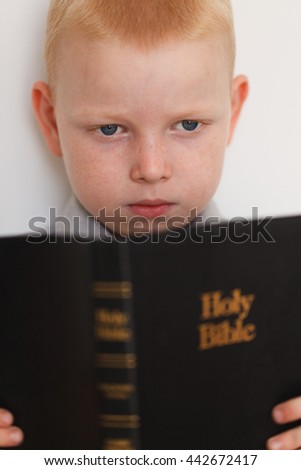 Little boy reading Holy Bible. High quality picture