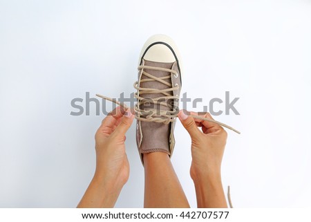 Tie her shoes canvas Sneakers on white background Royalty-Free Stock Photo #442707577