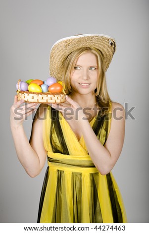 Young beautiful  woman with easter eggs. gray background