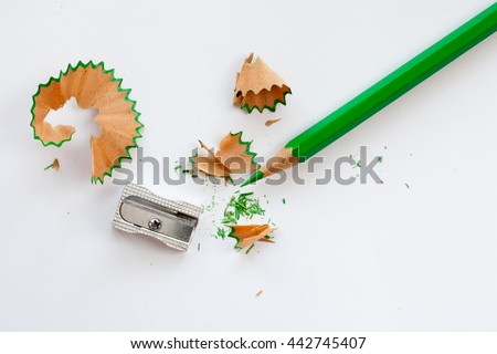 sharpener, green wooden pencil and pencil shavings on white Royalty-Free Stock Photo #442745407