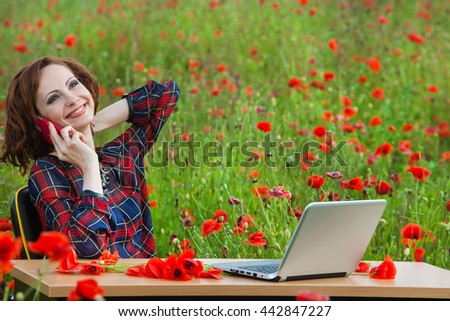 Portrait of a businesswoman working outdoors on laptop. Woman working with a laptop  in the middle of a a field in summer.