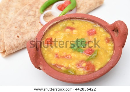 Chapati  roti/chapathi/fulka/paratha Indian whole wheat flat bread. Healthy fiber rich traditional North/South food Kerala India. Spicy dal/dhal/daal curry fry lentil soup. split pea in mud/clay pot.