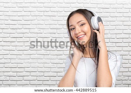 Beautiful young Asian woman wearing a set of headphones