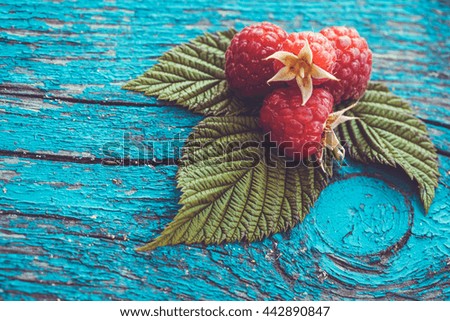 Fresh raspberry on a blue ancient wooden table