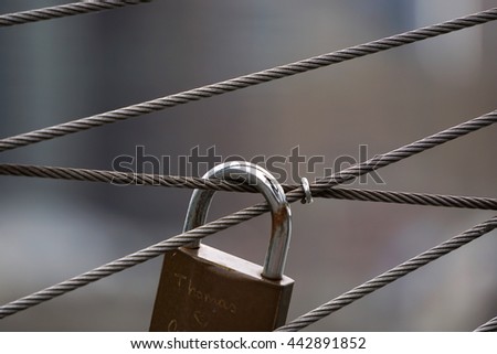 Love lock hanging along the Brooklyn Bridge suspension wires against the Manhattan skyline