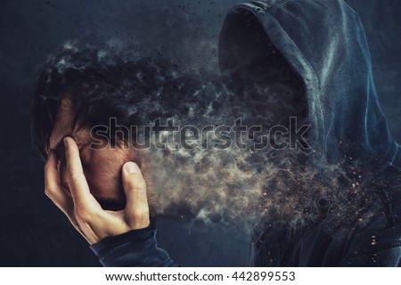 Hooded man taking off his face mask, revealing spooky faceless person behind
