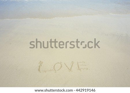 Design and writing word " love " on sand beach with soft the wave.