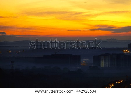 Mist in morning time over mountain and downtown with colorful sky before sunrise,select focus with shallow depth of field:ideal use for background.