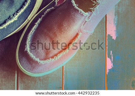 Old blue sneakers on hardwood floors.