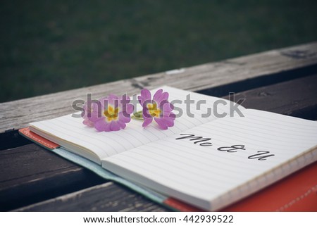 Me and you text on open notebook with flower on wooden table