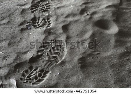 Close up boot or shoe print, with grip set deeply into dirty sand, left side. Hdr picture.