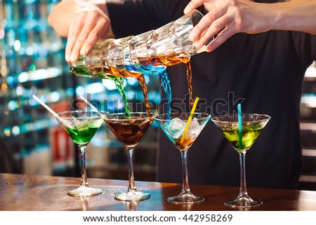 Barman show. Bartender pours alcoholic cocktails. Royalty-Free Stock Photo #442958269