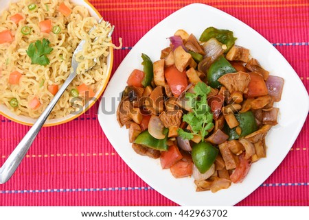 Hot and spicy Indian noodles / Chinese fried vegetables / instant with mushrooms, pepper and onion Mumbai, India. Asian meal. Traditional kids favorite junk food .