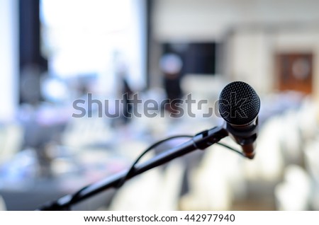 Black colored microphone isolated at an event. Bokeh background with copy space available.