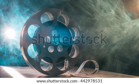 Movie reel of film in retro in the smoke of green and blueon a dark background