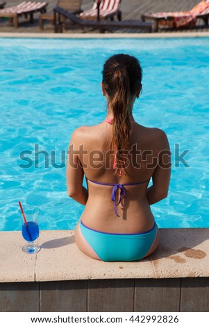 girl with cocktail near pool