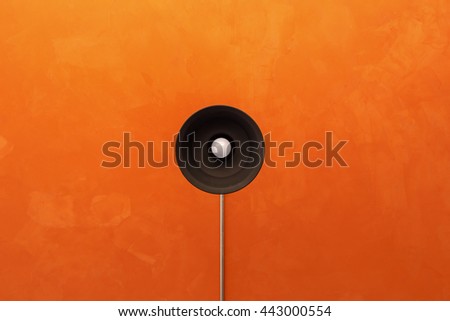 Lamp on the ceiling with orange cement background.