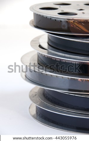 stack of old motion picture film reel on a white background