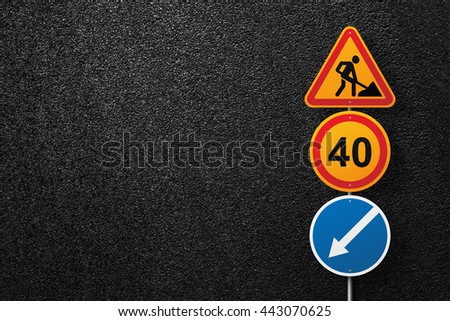 Road signs of the circular and triangular shape with a picture of a worker on a background of asphalt. Speed limit. The texture of the tarmac, top view.