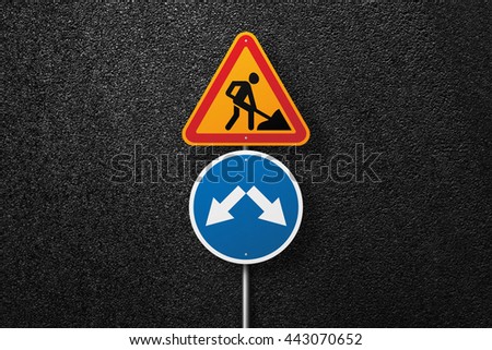 Road signs of the circular and triangular shape with a picture of a worker on a background of asphalt. Pointer. The texture of the tarmac, top view.
