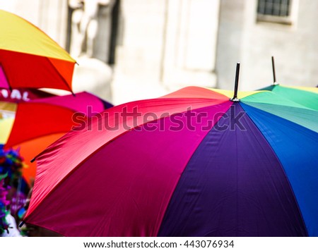 Multi tone umbrella with water droplets being used in the rain