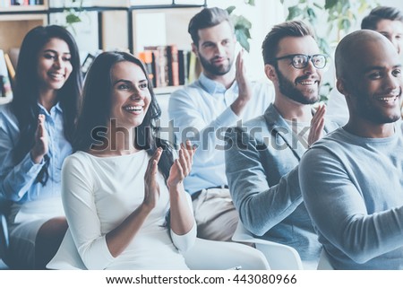 Great speech! Group of young cheerful people sitting on conference together and applauding  Royalty-Free Stock Photo #443080966