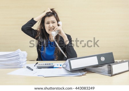 Closeup working woman are stressed from work paper and document file in front of her in hard work concept on blurred wooden desk and wall textured background in the meeting room under window light