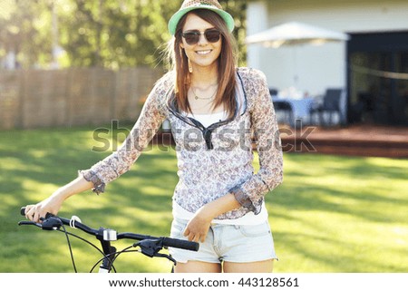 Picture of a happy woman with bike in the garden