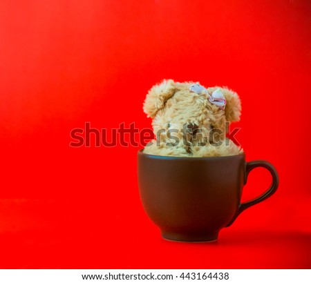 A coffee cup with teddy bear and red background