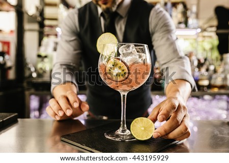 Expert barman is making cocktail at night club. Royalty-Free Stock Photo #443195929