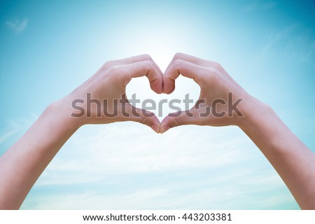 Human hands Heart shaped the sky in the background blurred.Environment Day concept. The power harmonious Royalty-Free Stock Photo #443203381