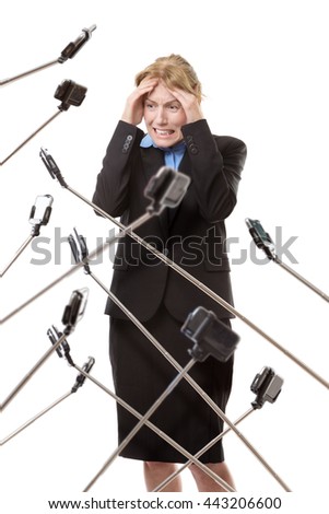 business woman surrounded by selfie stick not looking very happy