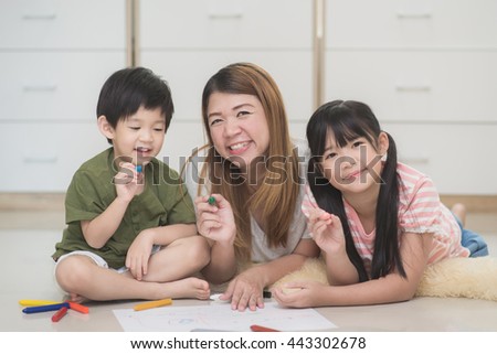 Asian family drawing picture with crayons