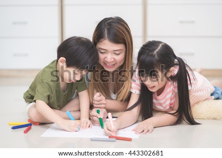 Asian family drawing picture with crayons