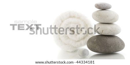 Stone tower and white towel with reflection on white background (with sample text)
