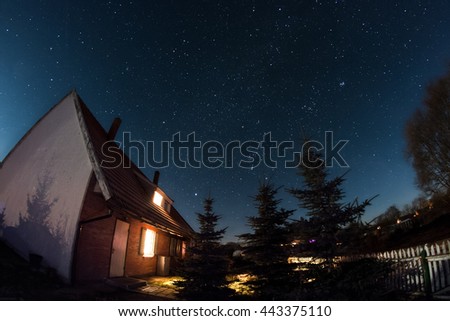 Deep dark starry sky over the small house late at night